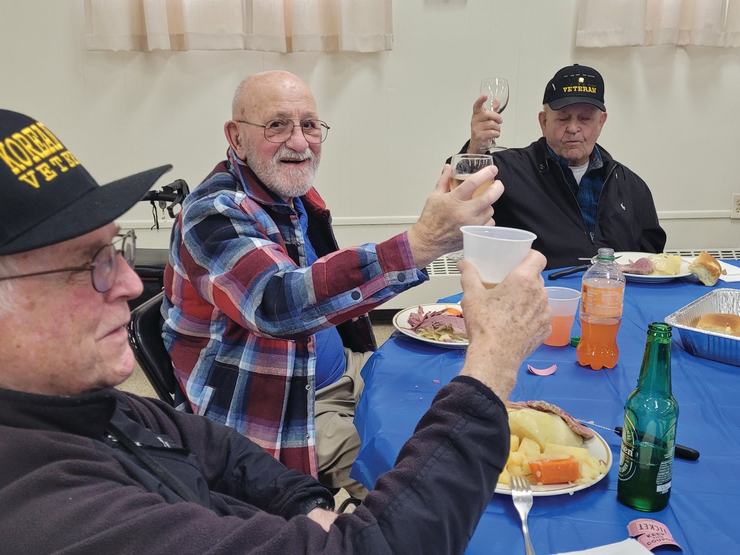 CHEERS: Ernie Cafolla, 97, at right, lifts his glass to toast his table-mates — Joe Mullen, 90, a Seekonk native and ex-Army first lieutenant; Donald LaBelle, 91, formerly of Charlestown, a former Air Force airman first class — who all lifted their bottles and goblets. (Sun Rise photos by Rory Schuler)